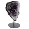 A polished purple amethyst geode mount on a black metal stand, photographed against a solid white background.