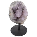 Amethyst geode crystal cluster on a black metal stand, photographed against a plain white background.