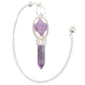 A silver chain pendulum featuring a faceted purple amethyst crystal point and a larger merkaba amethyst crystal, both set in silver-toned metal, shown on a plain white background.