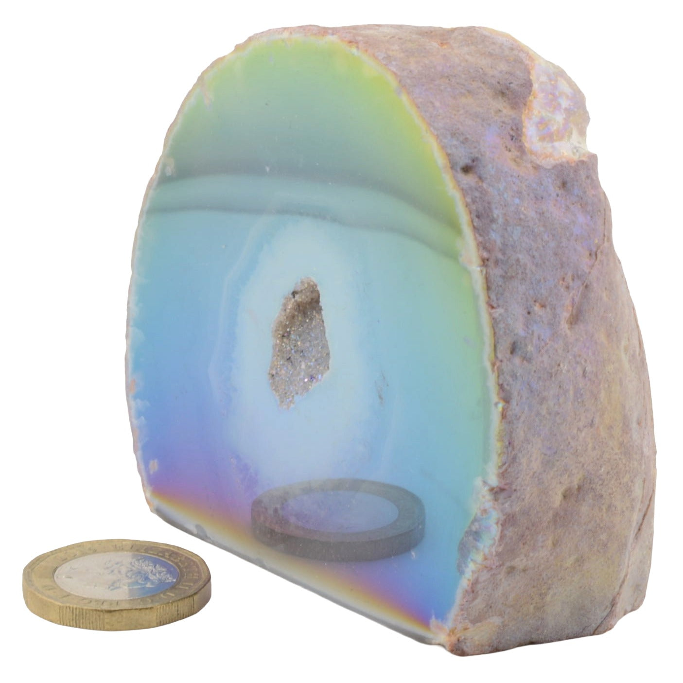 A polished semi-circular aura agate geode with iridescent blue, green, and purple bands, shown on a white background with a coin and circular base for scale.