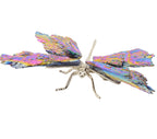 A metallic dragonfly body with iridescent, rainbow-colored aura kyanite wings and a silver body, shown against a plain white background.