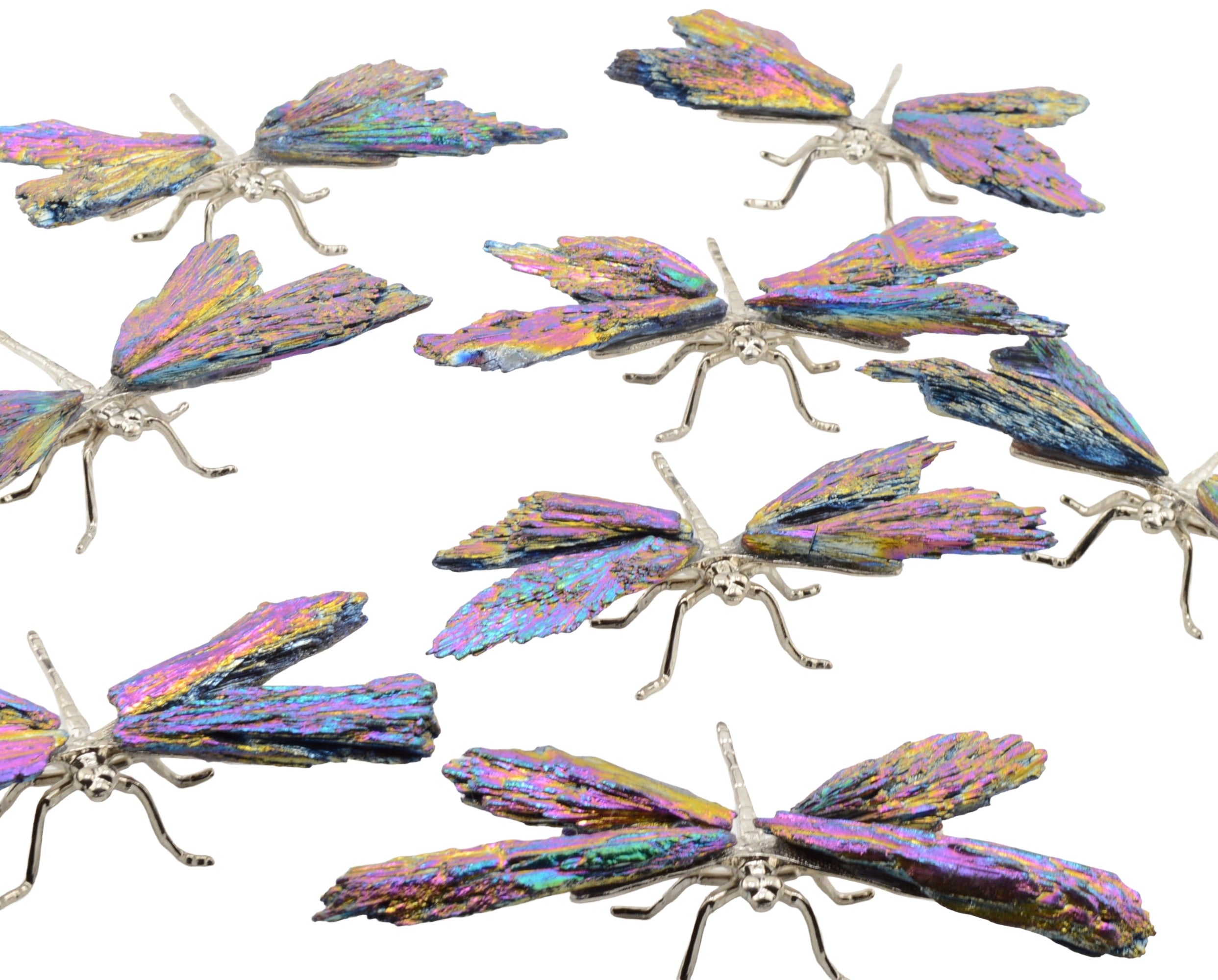 A set of dragonfly-shaped pieces with iridescent wings and silver-toned bodies and legs, arranged on a plain white background.