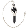 A Black Obsidian Pendulum featuring a point and merkaba. It has a silver coloured chain with bead. Pictured on a white background