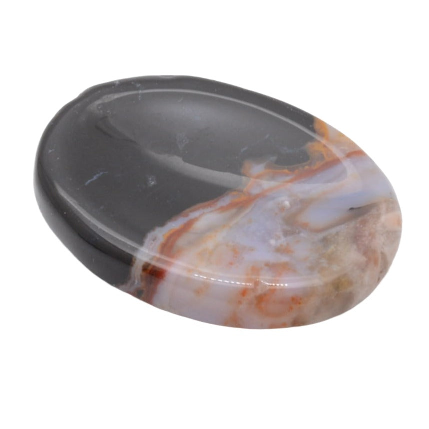 A polished oval gemstone worrysotone featuring a distinct colour transition from a dark grey to a marbled mix of white, orange, and light grey, shown on a plain white background.