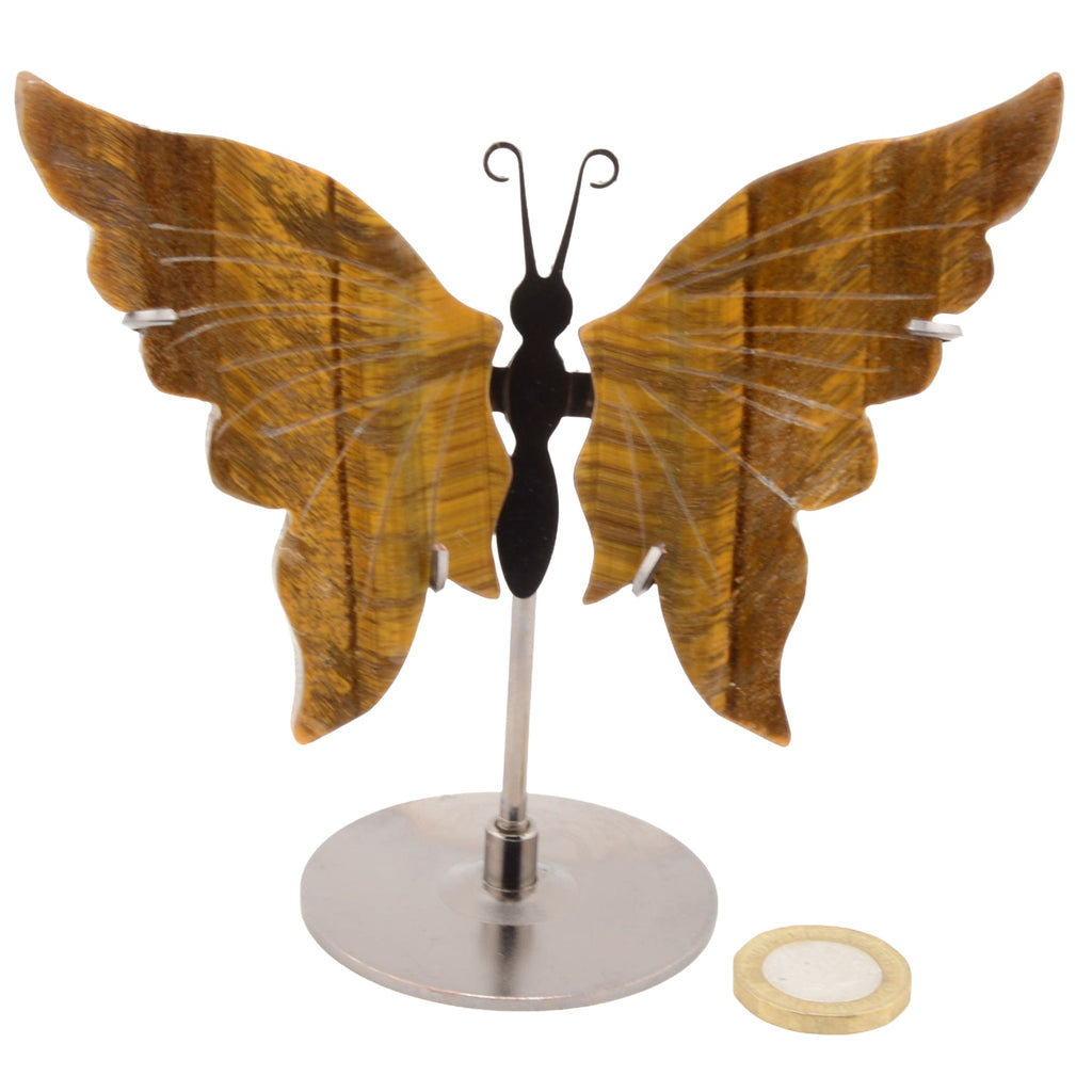 A butterfly-shaped display stand with large brown Tigers Eye Gemstone wings, a black ant-like body, and a silver metal stand, shown on a white background with a small round coin at the bottom right.