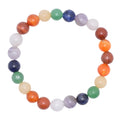 A beaded stretch bracelet made of polished gemstone beads in a rainbow chakra sequence, displayed on a clean white background.