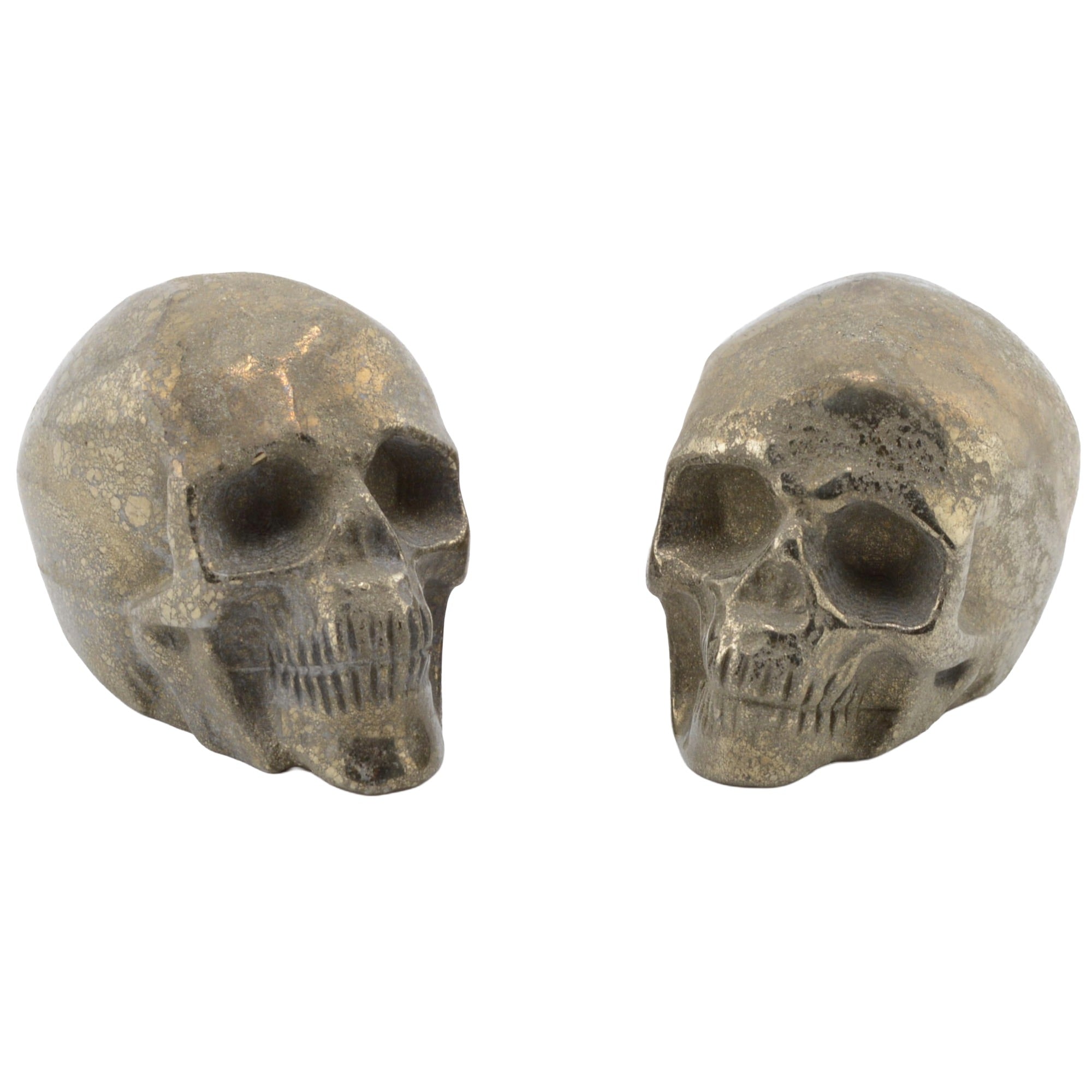 Two pyrite metallic skull-shaped decorative pieces shown side by side on a plain white background.