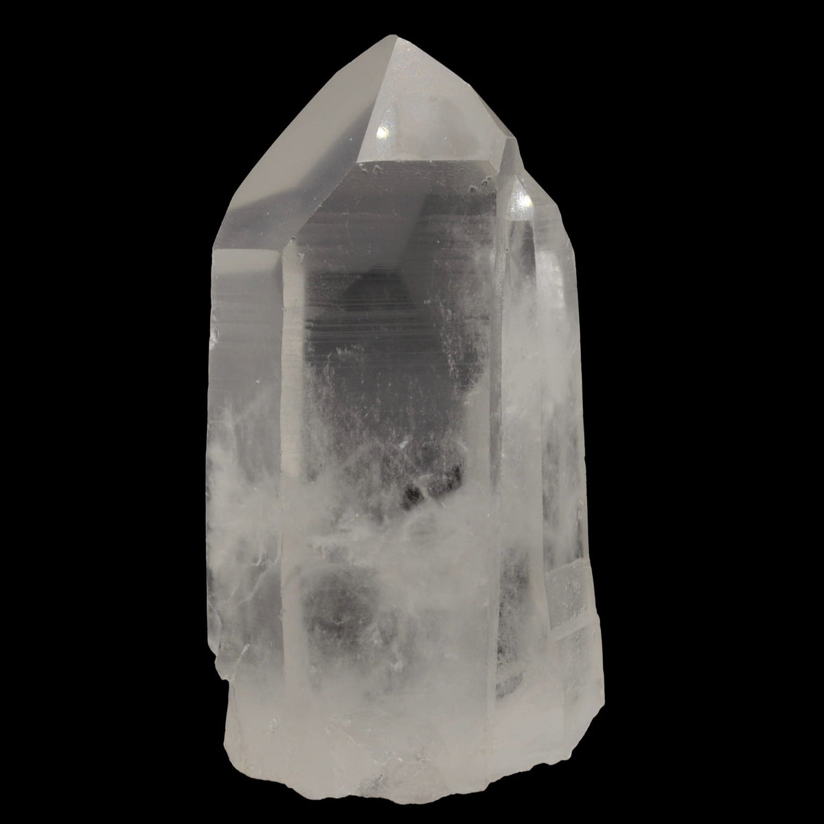 A natural clear quartz crystal point with visible internal inclusions and a rough, unpolished base, photographed against a solid black background.