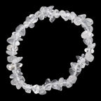 A clear quartz crystal chip bracelet made of irregular, faceted transparent stones, arranged in a circular shape against a solid black background.