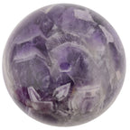 A polished purple amethyst crystal sphere with visible natural crystal facets and cloudy white inclusions, isolated on a white background.