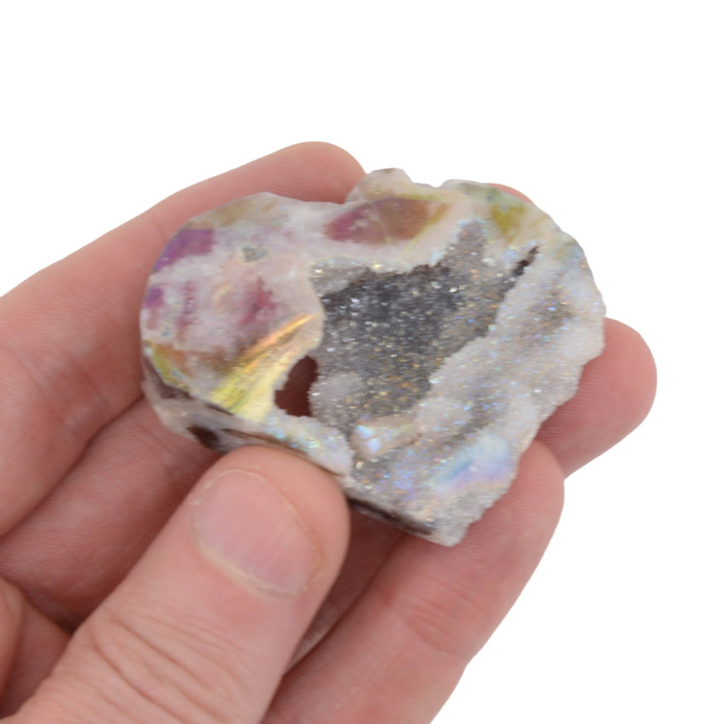 A hand holding a  Druzy Rainbow Aura Sphalerite Heart Shaped Carving. Measuring 55mm on a white background