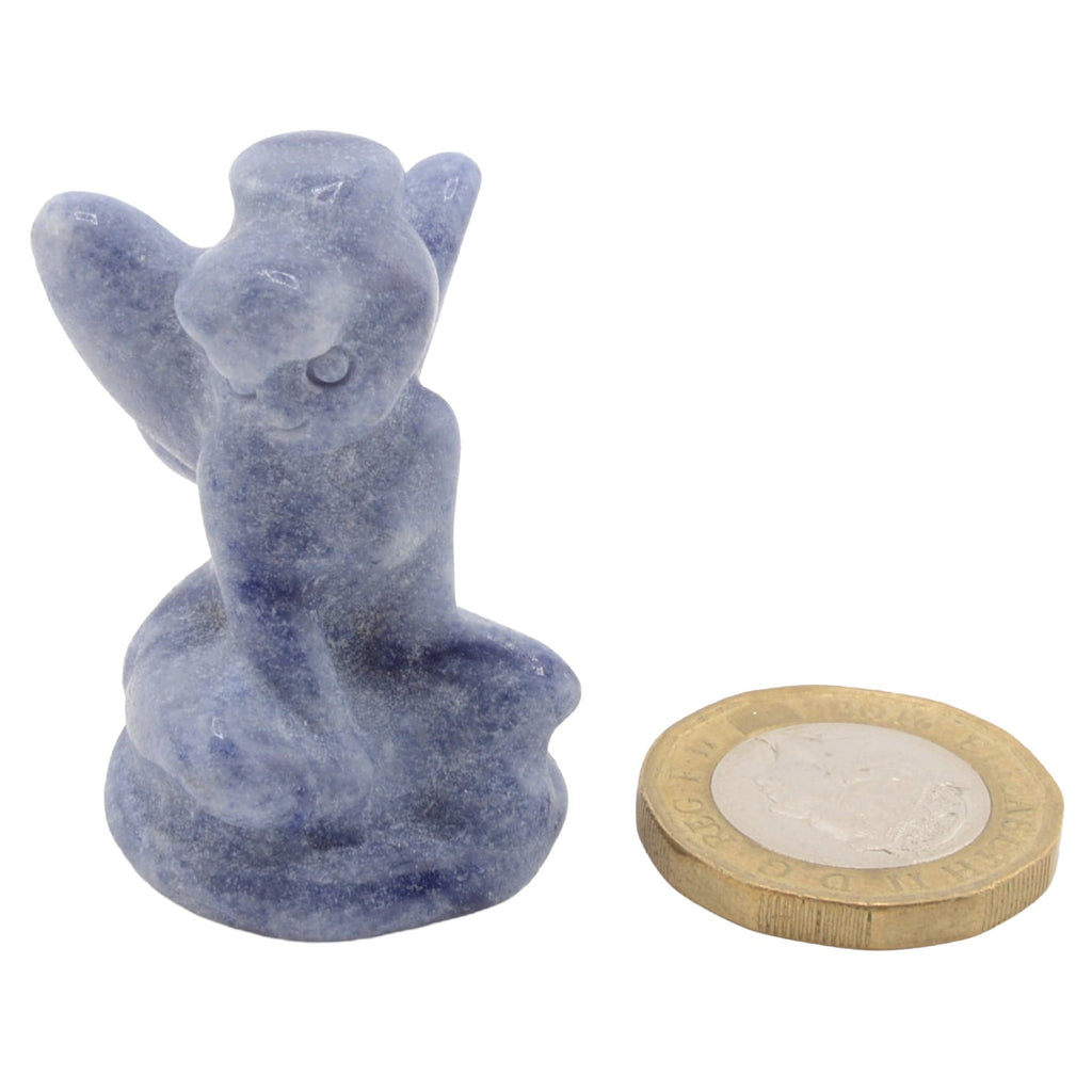 A small blue gemstone figurine of a flower fairy, shown next to a coin for scale, on a plain white background.