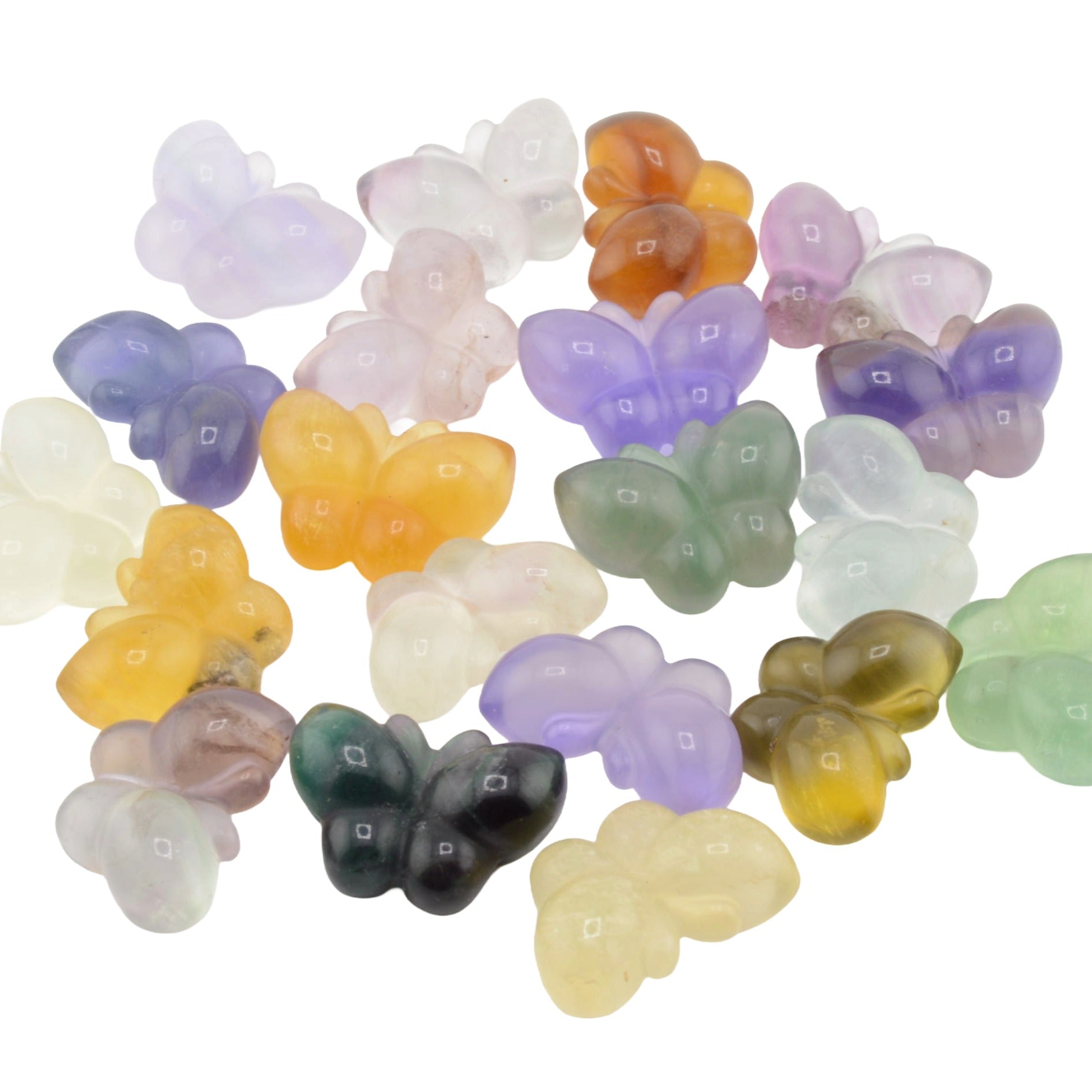 A group of small fluorite crystal butterfly carvings in multiple pastel and neutral colors, including purple, green, yellow, orange, pink, and white, arranged on a plain white background.