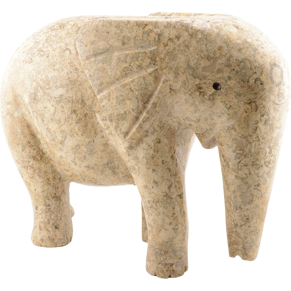 A carved elephant figurine made from natural beige and tan fossil stone, set against a plain white background.