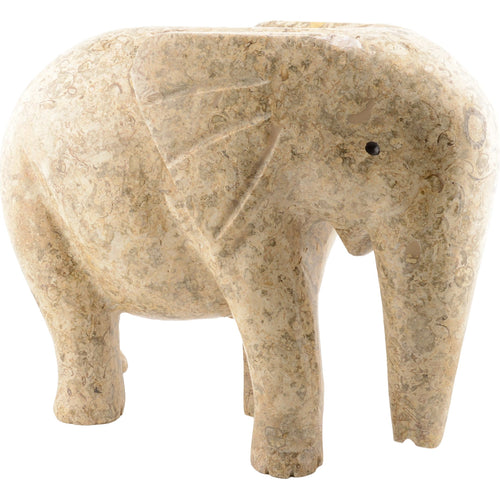 A carved elephant figurine made from natural beige and tan fossil stone, set against a plain white background.