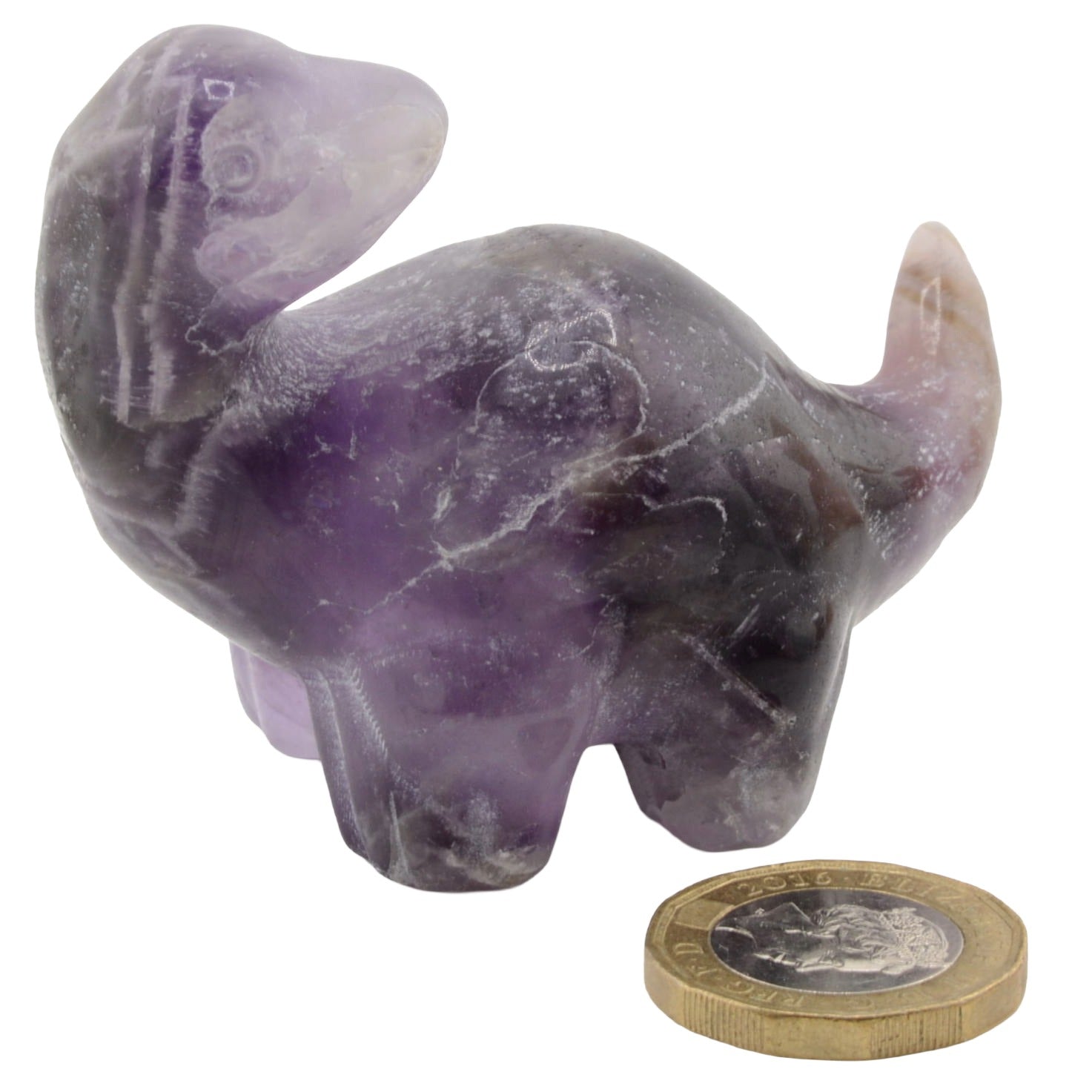 A small carved amethyst dinosaur figurine shown on a white background next to a British coin for scale.