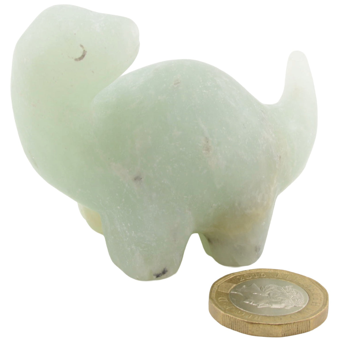 A pale green gemstone dinosaur figurine,  shown on a white background with a coin placed in front for scale.
