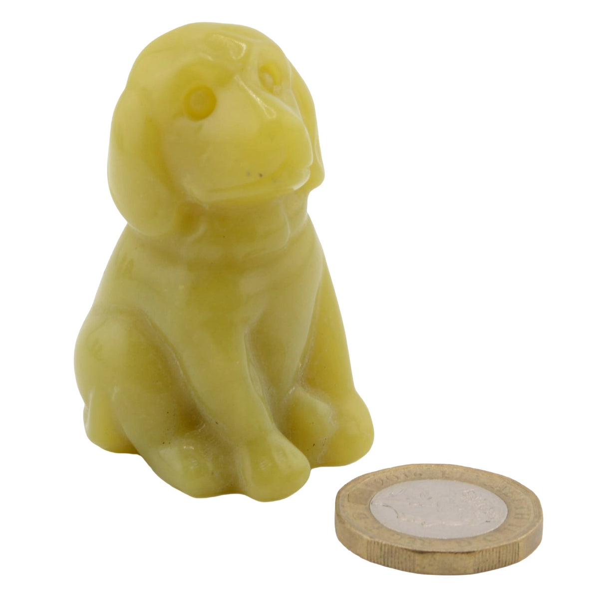 A small yellow dog figurine shown next to a coin for scale, on a plain white background.
