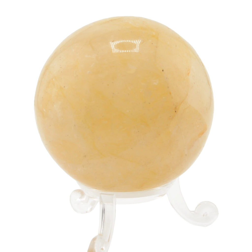 A smooth, polished yellow-orange  golden healer quartz crystal sphere displayed on a clear acrylic stand against a white background.