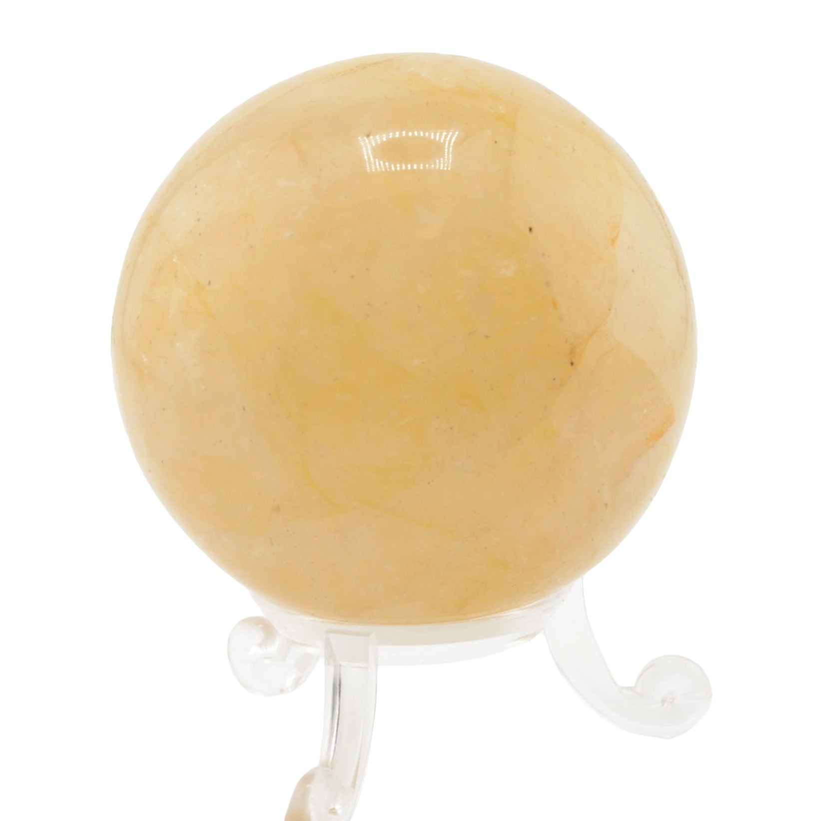 A smooth, polished yellow-orange  golden healer quartz crystal sphere displayed on a clear acrylic stand against a white background.