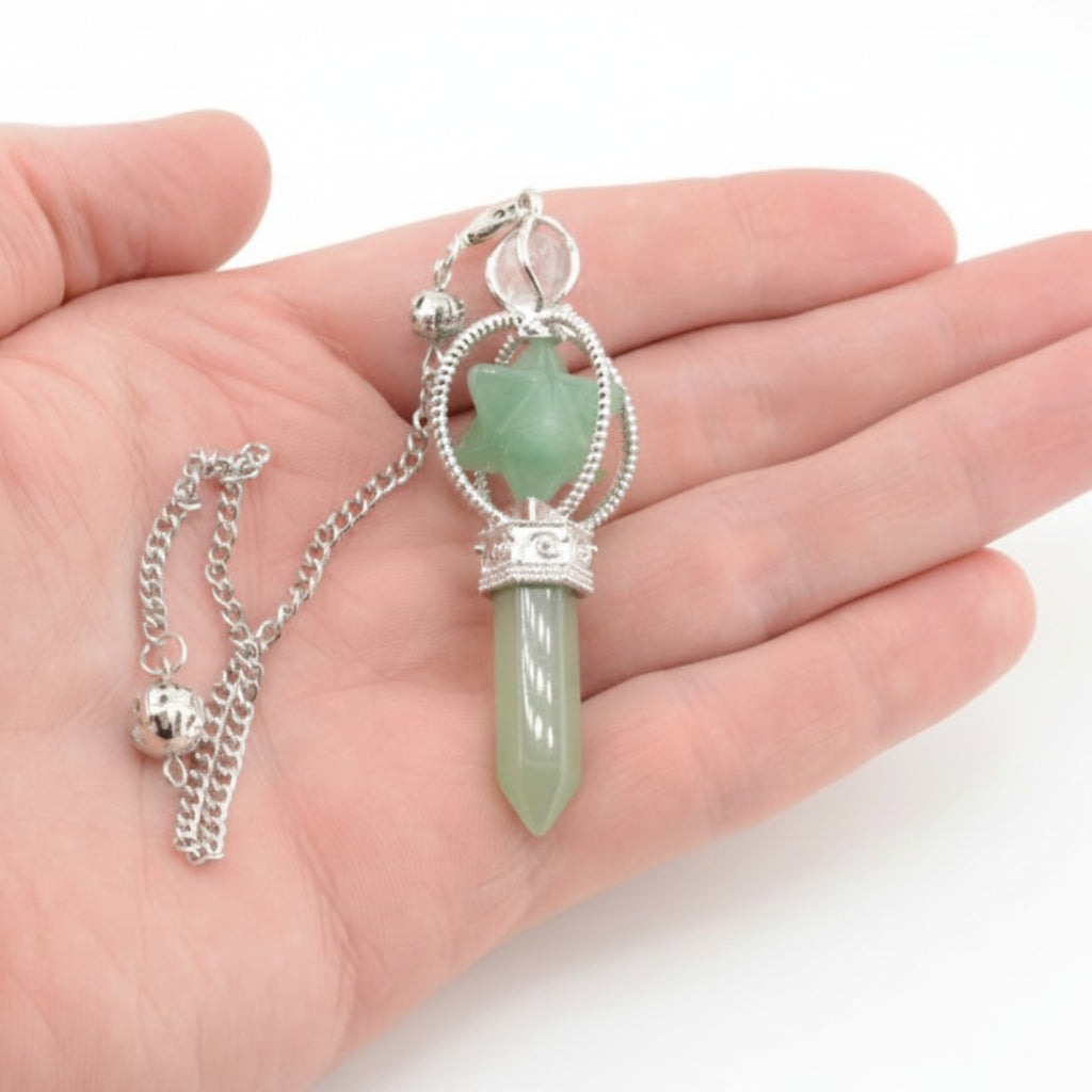 A green aventurine gemstone point & merkaba pendulum, featuring a silver chain with ball. Held in a hand with a white background