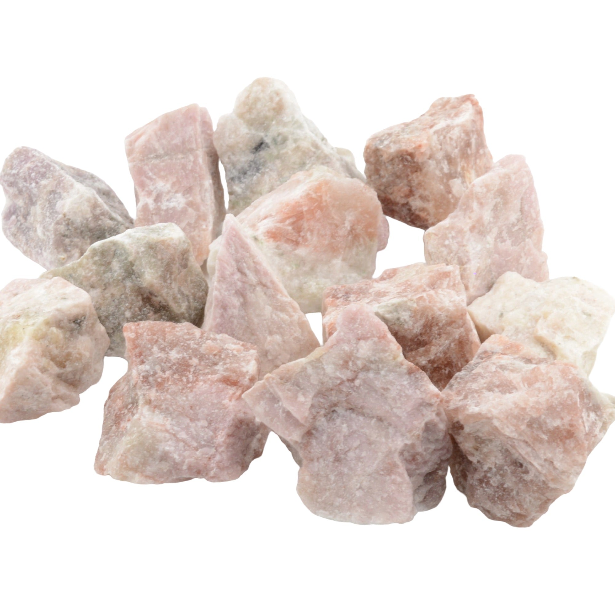 A pile of rough, unpolished pink sodalite which is known as hackmanite on a plain white background.