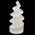 A modern abstract spiral unicorn horn sculpture made of semi-translucent selenite crystal, set against a solid black background.