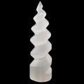 A white spiral-shaped selenite crystal tower sculpture made from selenite, photographed against a solid black background.
