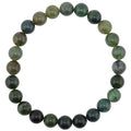 A beaded stretch bracelet made of polished moss agate gemstone beads in shades of green, dark forest green, arranged in a circular shape on a plain white background.