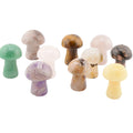 A set of tensmall mushroom-shaped polished gemstone carvings in various colors, including green, pink, brown, purple, yellow, and black, arranged on a plain white background.