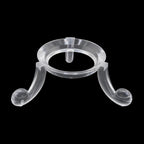 A clear acrylic jewelry display stand with a circular top and two curved legs, shown against a solid black background.