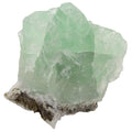 A raw light green crystal fluorite mineral specimen with a rough white and brown matrix base, isolated on a solid white background.