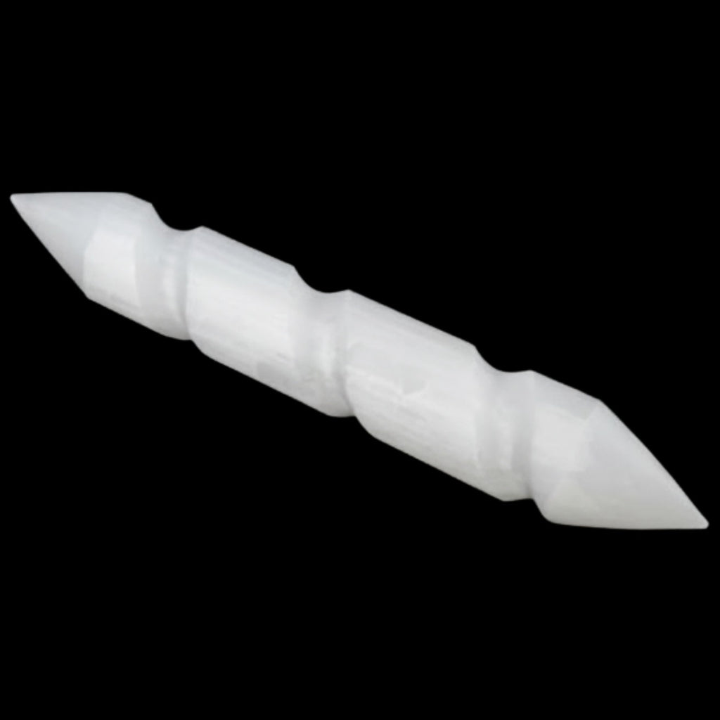 A selenite wand cylindrical tool with pointed ends, shown diagonally against a solid black background.