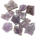 A group of rough amethyst crystal clusters with natural jagged edges, showing various shades of purple and lavender, isolated on a white background.