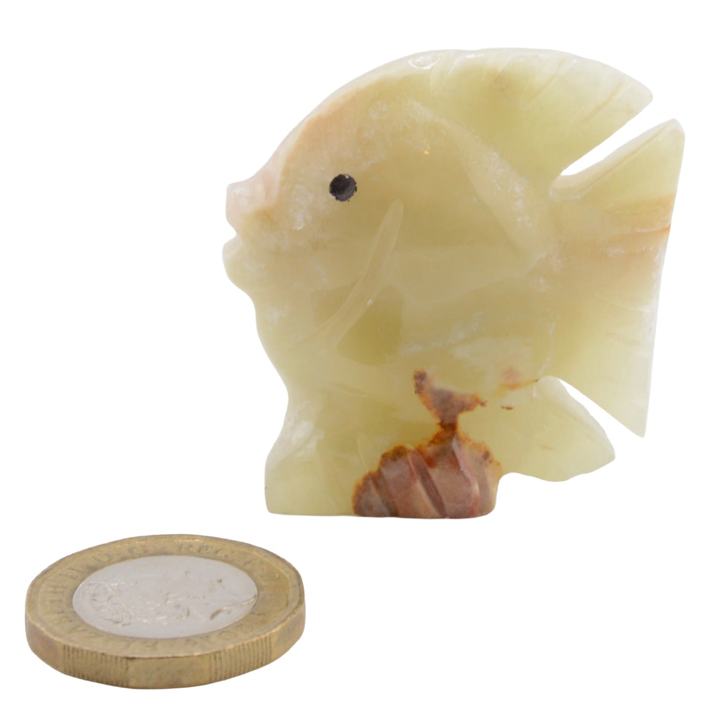 A small carved fish figurine in banded calcitr with natural brown veining and a black eye, shown next to a coin for scale on a white background.