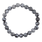 A beaded stretch bracelet made of snowflake obsidian 8mm polished round beads with a black and white mottled, stone-like pattern, shown on a plain white background.