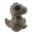 A small dinosaur T-Rex figurine made of gemstone , featuring a dark gray-brown body and glossy black eyes, isolated on a white background.