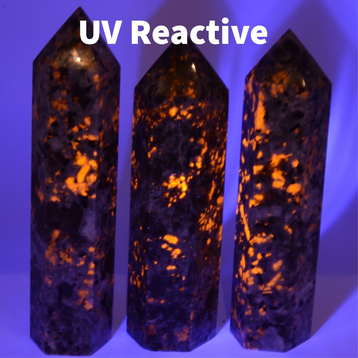 Three Yooperlite Tower under UV light showing the orange UV reaction
